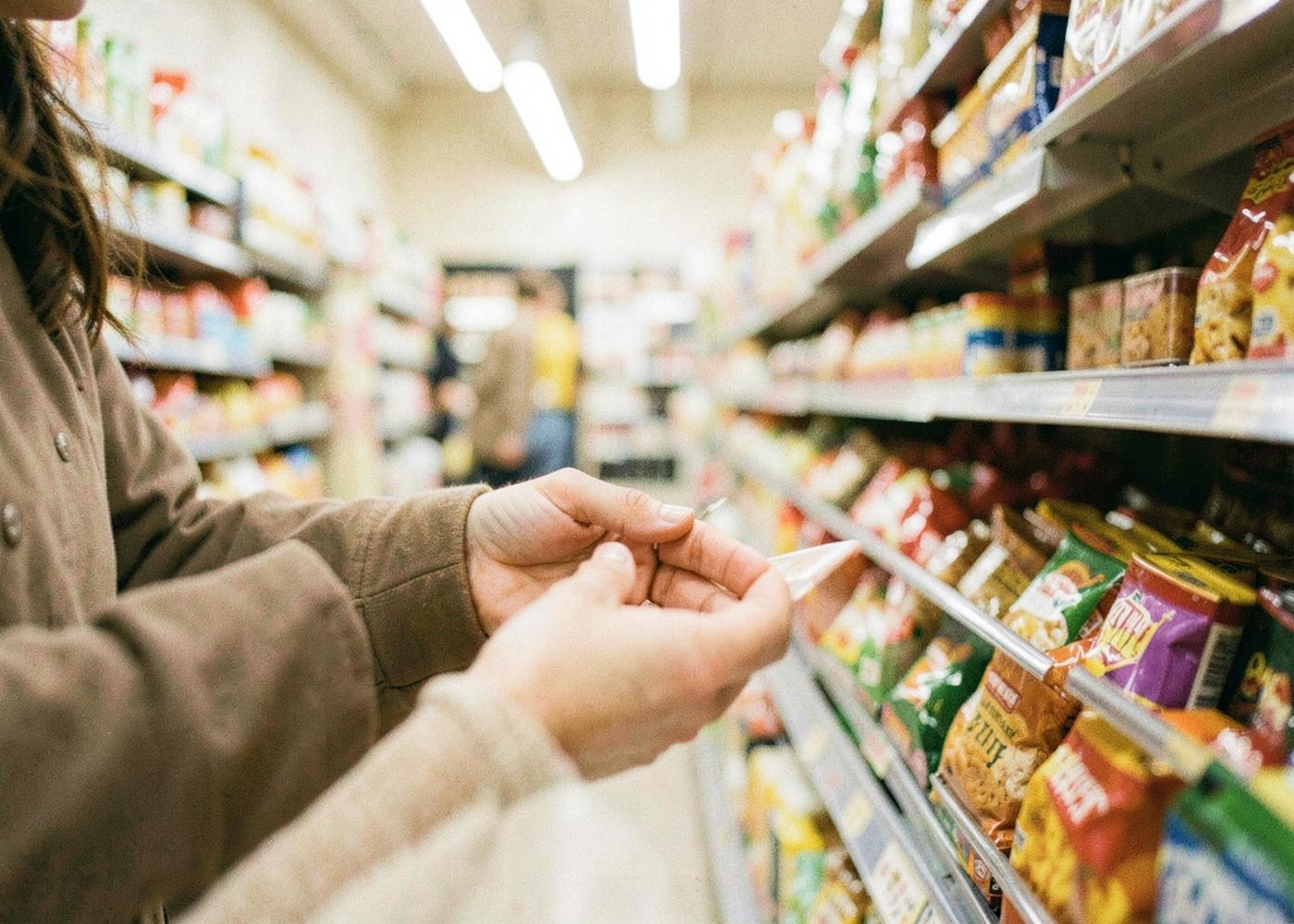 Shoppers choosing between products on a busy grocery shelf